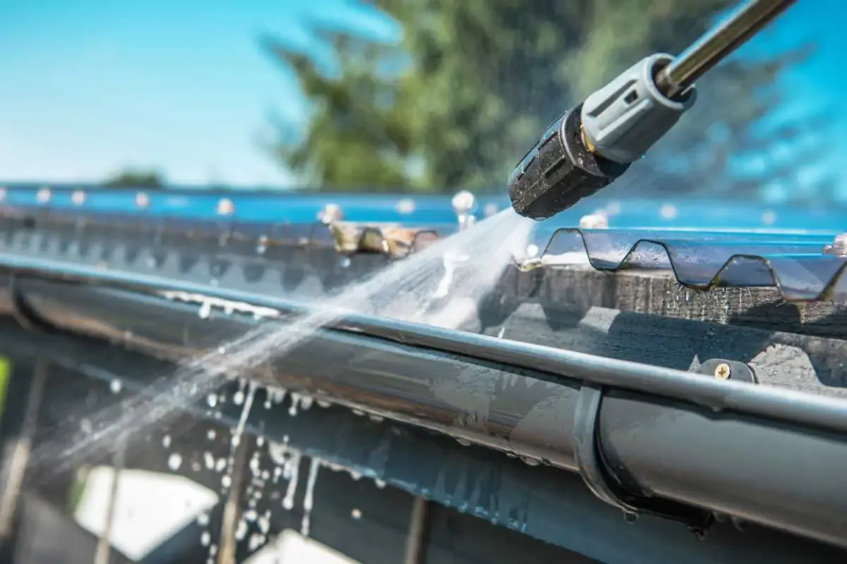 Dakgoot en regenpijp worden schoongemaakt om verstopping te voorkomen